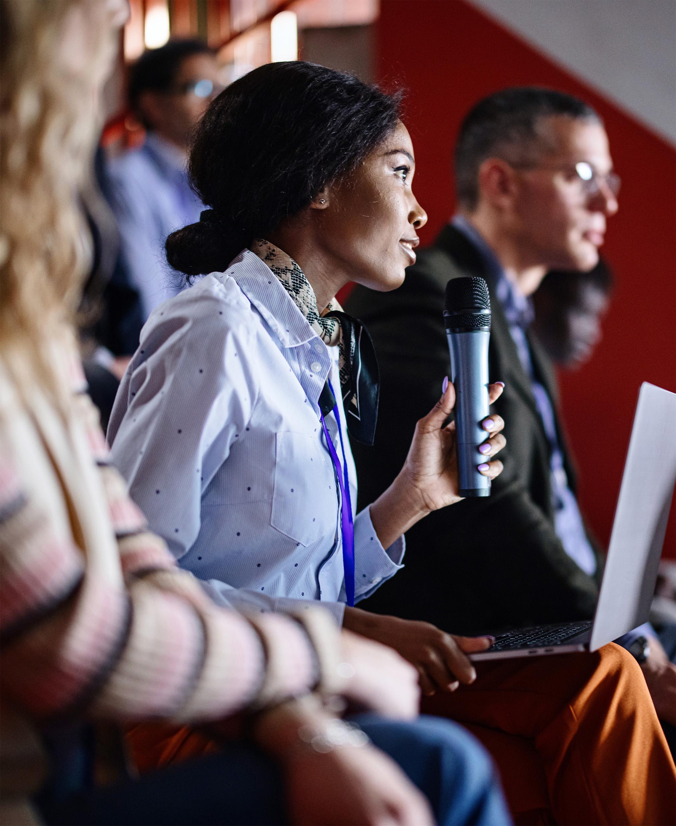 Woman holding microphone at conference